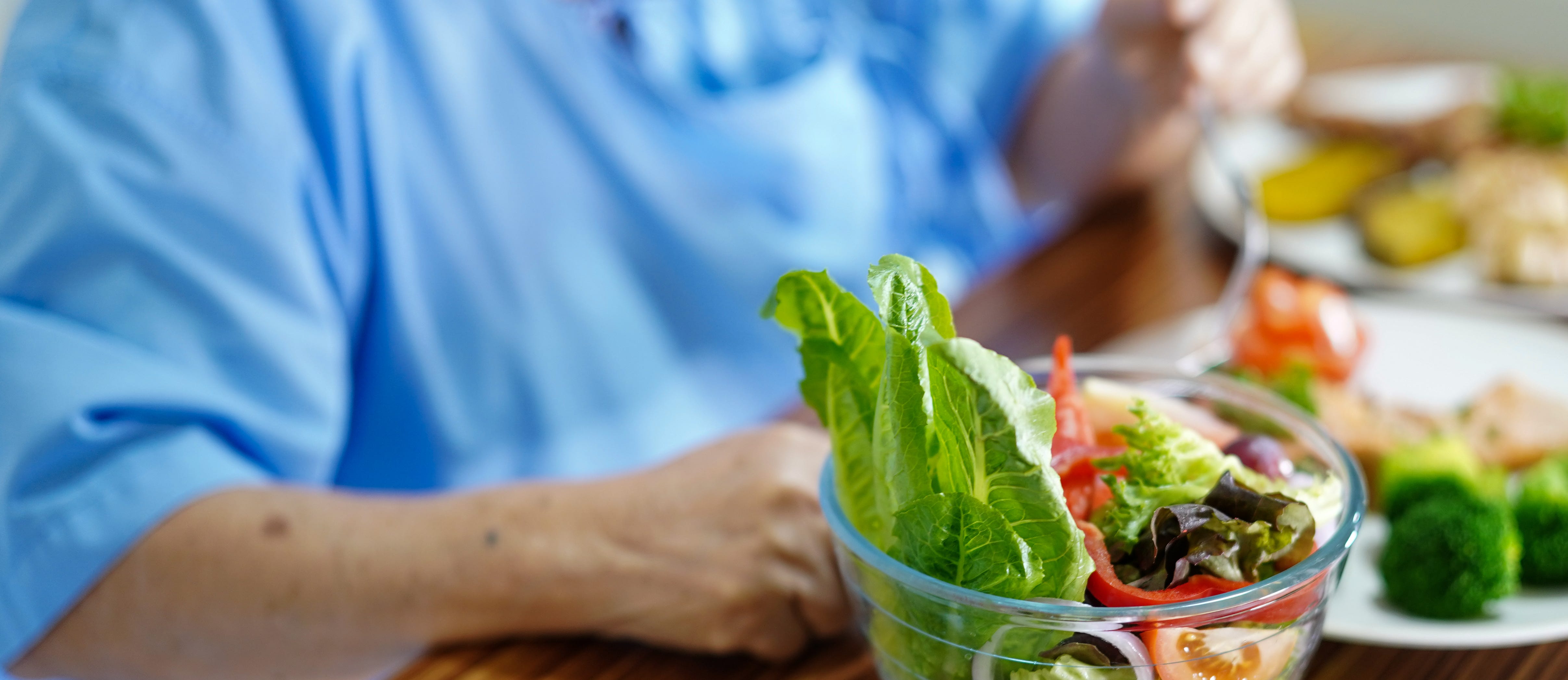 shot of food on a table, and elderly arms eating it