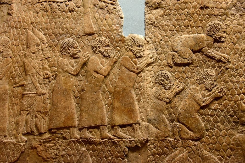 Assyrian soldiers parading the prisoners of ward before Sennacherib (on the right, not shown here). Most likely those represent the heads of the rebellion. All of them are bare-footed and wear nothing on their head; a sign of humiliation. All of them seem to ask for mercy. One prostrates, two kneels and the other 3 stand before the king. Most likely, they were executed later on. From Nineveh (modern-day Mosul Governorate, Iraq), Room XXXVI of the South-West Palace, panels 11-13. The British Museum, London. Photo © Osama S. M. Amin.