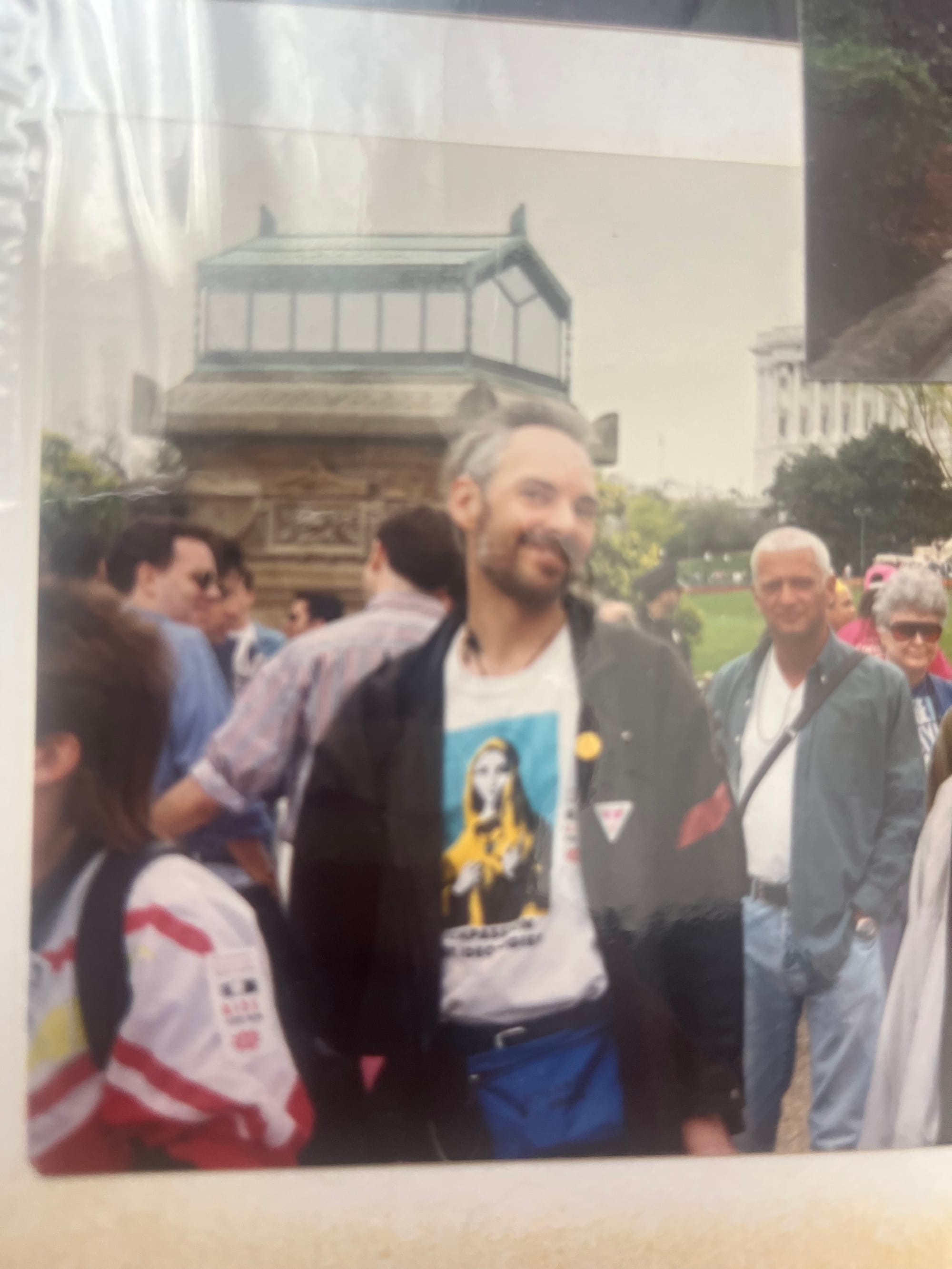 Photo of a lot of people on the Mall in DC, with a greying, smiling white man looking at the camera